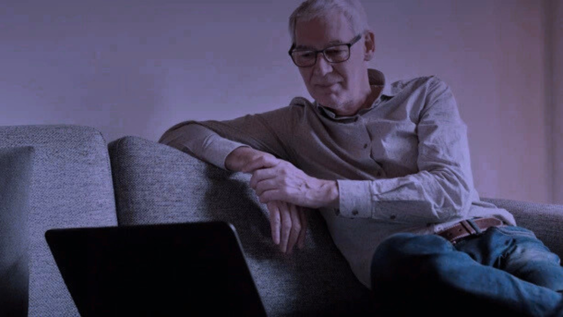 Ældre mand med pc på sofa